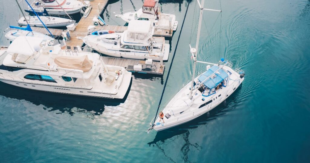 Sailboat being docked at a marina by a delivery captain